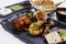 Tandoori platter with chicken tikka, grilled prawns, and paneer along with dal makhani, wheat bread and chutneys, Indian food