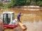 Tangerang, Indonesia, August 2022, a fisherman catching fish in the murky water of a lake being dredged by an excavator