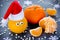 Tangerine with eyes in Santa hat, Christmas Xmas New Year concept, fresh ripe and sweet mandarin orange clementine tangerine