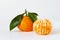 Tangerine Orange or clementine with green leaf with peeled orange