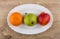 Tangerine, pear and nectarine in oval dish on wooden table