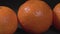 Tangerines close up on a black background. The rotation of tropical fruits.