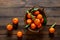 Tangerines fresh mandarin oranges clementines with leaves on wooden background. Top view copy space