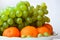 Tangerines and grapes lying on a large plate