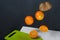 Tangerines and kiwis float above the table surface. Some are cut into pieces. Fruit levitation