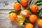 Tangerines with leaves and bottle of essential citrus oil