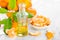 Tangerines with leaves and bottle of essential citrus oil on a white background