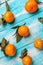 Tangerines with leaves lie on a wooden blue table. Strips of boards on the diagonal. Vertical orientation. Close up