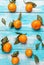 Tangerines with leaves lie on a wooden blue table. Strips of boards horizontally. Vertical orientation