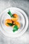 Tangerines with leaves on plate - citrus fruits and healthy eating flatlay concept