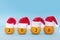 Tangerines in little Santa Claus hats on a blue background with the inscription 2020. New Year holiday concept, copy space