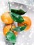 Tangerines, mandarines, clementines in winter holiday time, citrus fruits on plate with glowing snow and glitter on flatlay