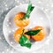 Tangerines, mandarines, clementines in winter holiday time, citrus fruits on plate with glowing snow and glitter on flatlay