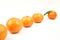 Tangerines in one line on a white background first go tangerine in focuse with green leafe