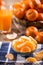 Tangerines, peeled tangerine and tangerine slices on a blue cloth. Mandarine juice