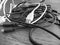 Tangle of dusty computer cables with sockets on the table . Black and white photo