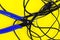 Tangled charger wires. Black wire on a yellow background