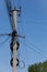 Tangled electric cables on concrete post. Blue sky, selective focus, vertical orientation