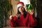 Tangled garland. A young woman in a Santa hat unraveling a garland on Christmas Eve.