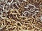 Tangled gold and silver chains close up. Textured metallic background