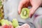 Tangy Delight: Woman Holding a Fresh Green Kiwi Fruit