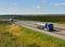 Tank truck MAN driving on highway. `B.S.A.T.` specifics of the truck transportation of liquid goods. Metal chrome cistern tanker