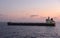 Tanker ship departing from the Suez Canal during a sunrise.