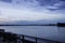 A tanker ship sailing along the flowing waters of the Mississippi River at sunset with blue sky and powerful clouds in New Orleans