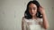 Tanned beautiful brunette bride in white wedding dress sitting on the chair. In the hands holding the cotton branches