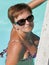 Tanned caucasian middle aged woman looking from the outdoor pool