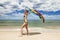 Tanned girl in bikini posing on the beach with colored pareos