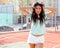 Tanned, long-haired brunette posing with arms raised on a basketball court in shorts and a T-shirt. Freedom, love