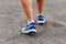 The tanned man feet in running shoes close outdoors