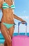 Tanned shaped beach body with pink suitcase