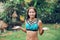 A tanned, slender woman in a swimsuit, posing with her eyes closed, under a refreshing tropical rain. Summer vacation and travel