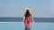 Tanned woman in bikini admiring sea landscape sitting endless swimming pool summer travel vacation