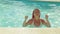 Tanned woman with pigtails dancing in the pool