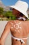 Tanning lotion on woman\'s shoulder.
