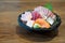 A tantalizing display of Japanese sashimi, elegantly served in a pristine bowl, resting on a rustic wooden table. Experience the