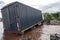 TANZANIA, ARUSHA - JAN 2020: Heavy Cargo Truck Stuck in the River. Maasai people Standing on the Shore. Ford at African