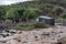 TANZANIA, ARUSHA - JAN 2020: Maasai people Standing on the Shore Deciding what to do while Heavy Cargo Truck Stuck in