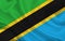 Tanzania country flag on wavy silk fabric background panorama