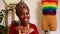 tanzanian woman with snake print turban over hear creating a colorful dress for pride parade in her dressmaking showroom