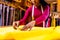 tanzanian woman with snake print turban over hear working in fabrics shop