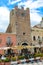 Taormina, Sicily, Italy - Apr 8th 2019: Tourists in restaurants and cafes gardens on historical Piazza IX Aprile square in front