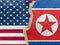 Tape on U.S.A and that of North Korea flag on cracked wall