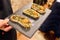 Tapenade of anchovies and couscous on toast on a black tray, still life