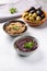 Tapenade - paste made from olives. Bowls with spreadable black and green olive cream on concrete background