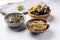 Tapenade - paste made from olives. Bowls with spreadable black and green olive cream on concrete background