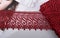 Tapes of red vinous gentle guipure, beauty lace fabric on light background